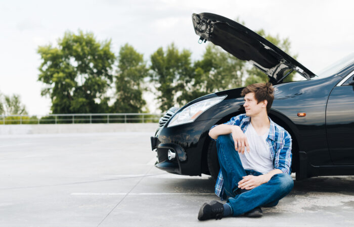 front-view-man-sitting-near-car